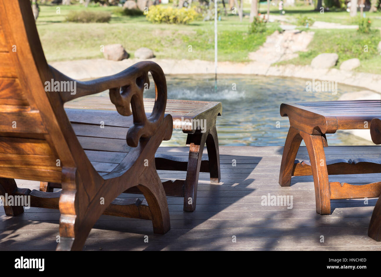 Deux table et chaises à côté étang dans jardin sur plancher bois Banque D'Images