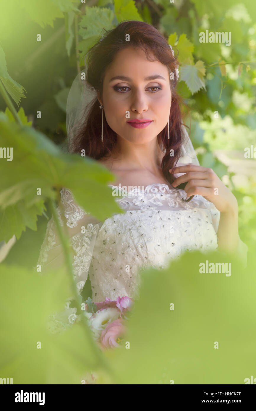 Superbe jeune femme posant dans un jardin d'été vert Banque D'Images