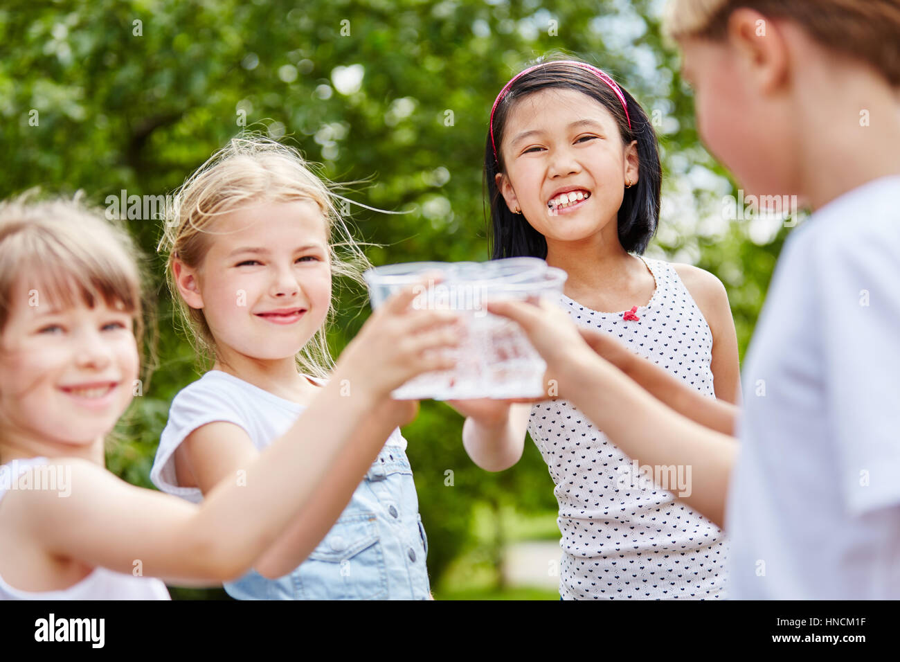 Trois filles de trinquer leurs verres d'eau at Birthday party Banque D'Images