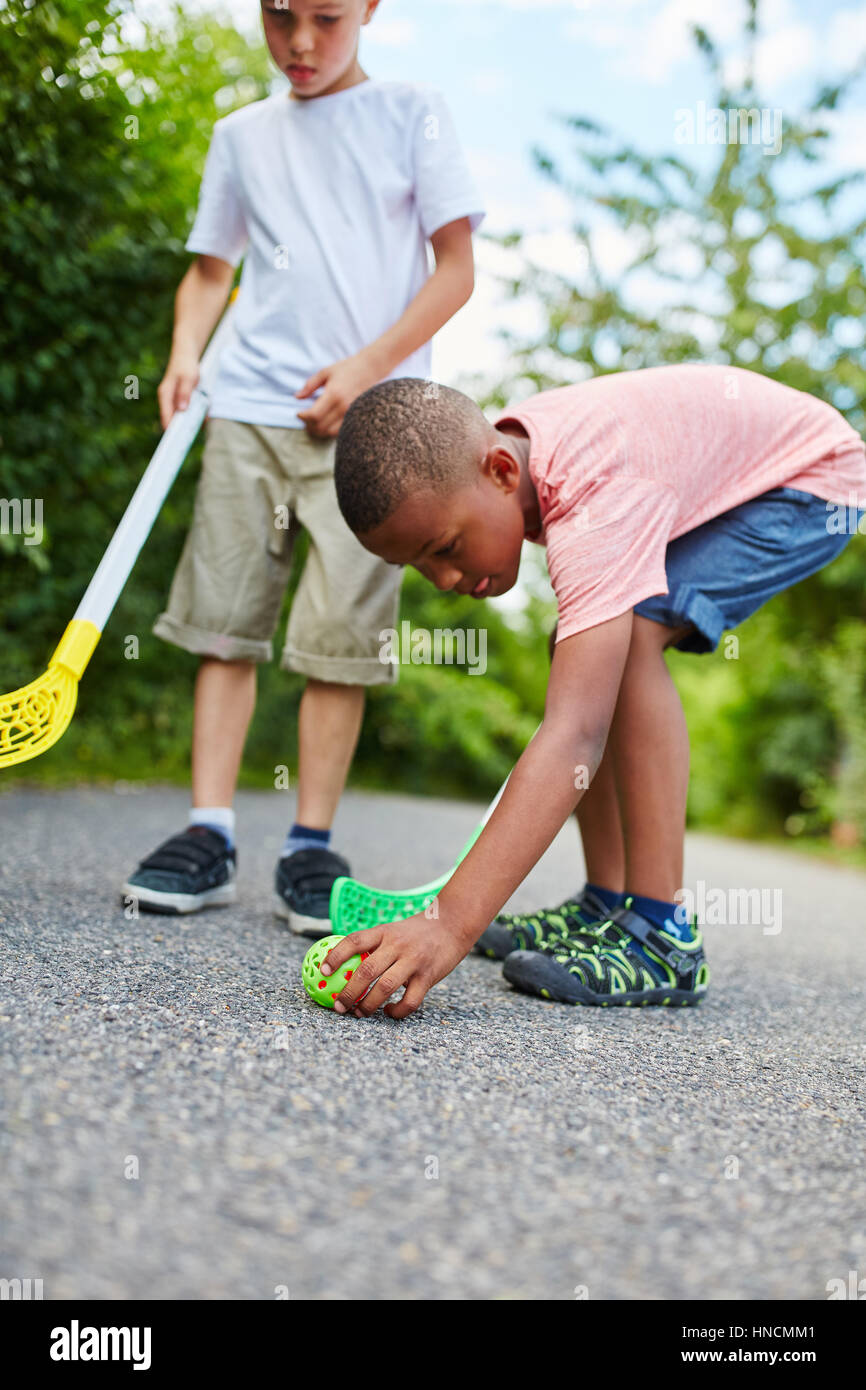 Deux enfants jouant au hockey de rue avec balle dans le parc Photo Stock -  Alamy