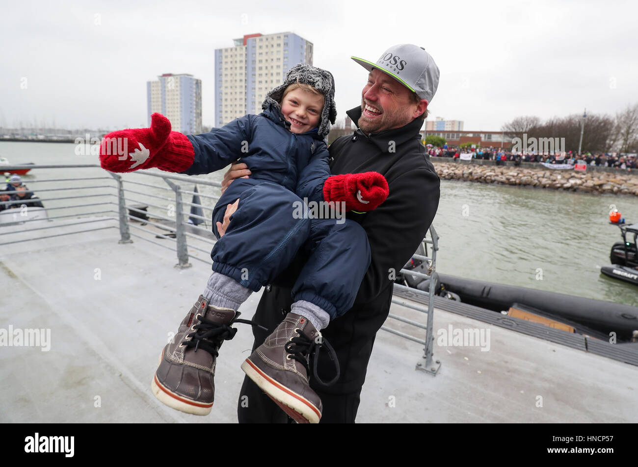 Marin britannique Alex Thomson célèbre avec son fils Oscar, après l'arrivée  à terre après avoir pris part à un défilé de la voile comme il a fait son  chemin dans le port