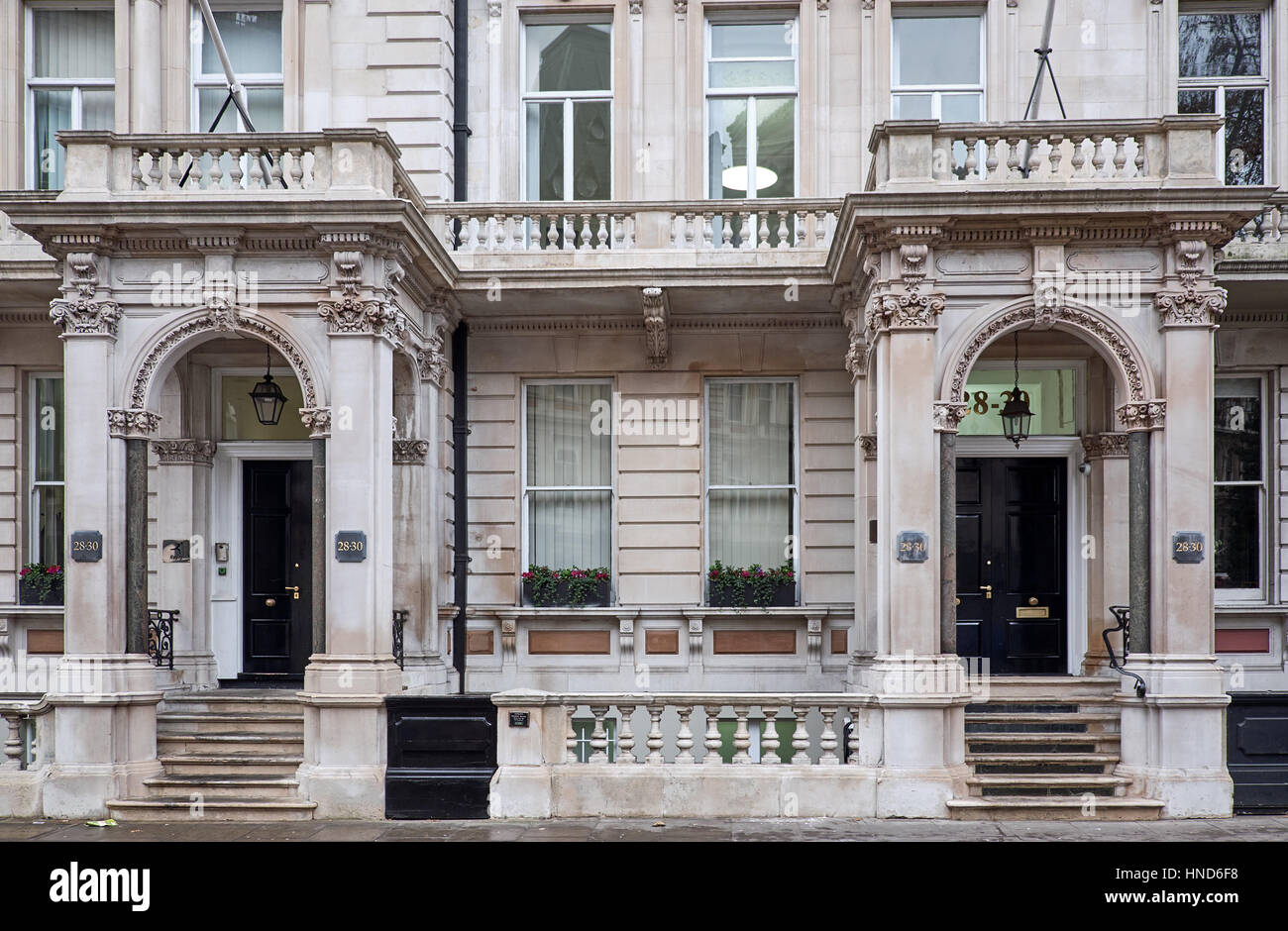 Façade richement décorée avec des décorations sophistiquées autour de l'entrée des abris, appuyée sur des colonnes, d'un bâtiment dans la ville de Londres Banque D'Images