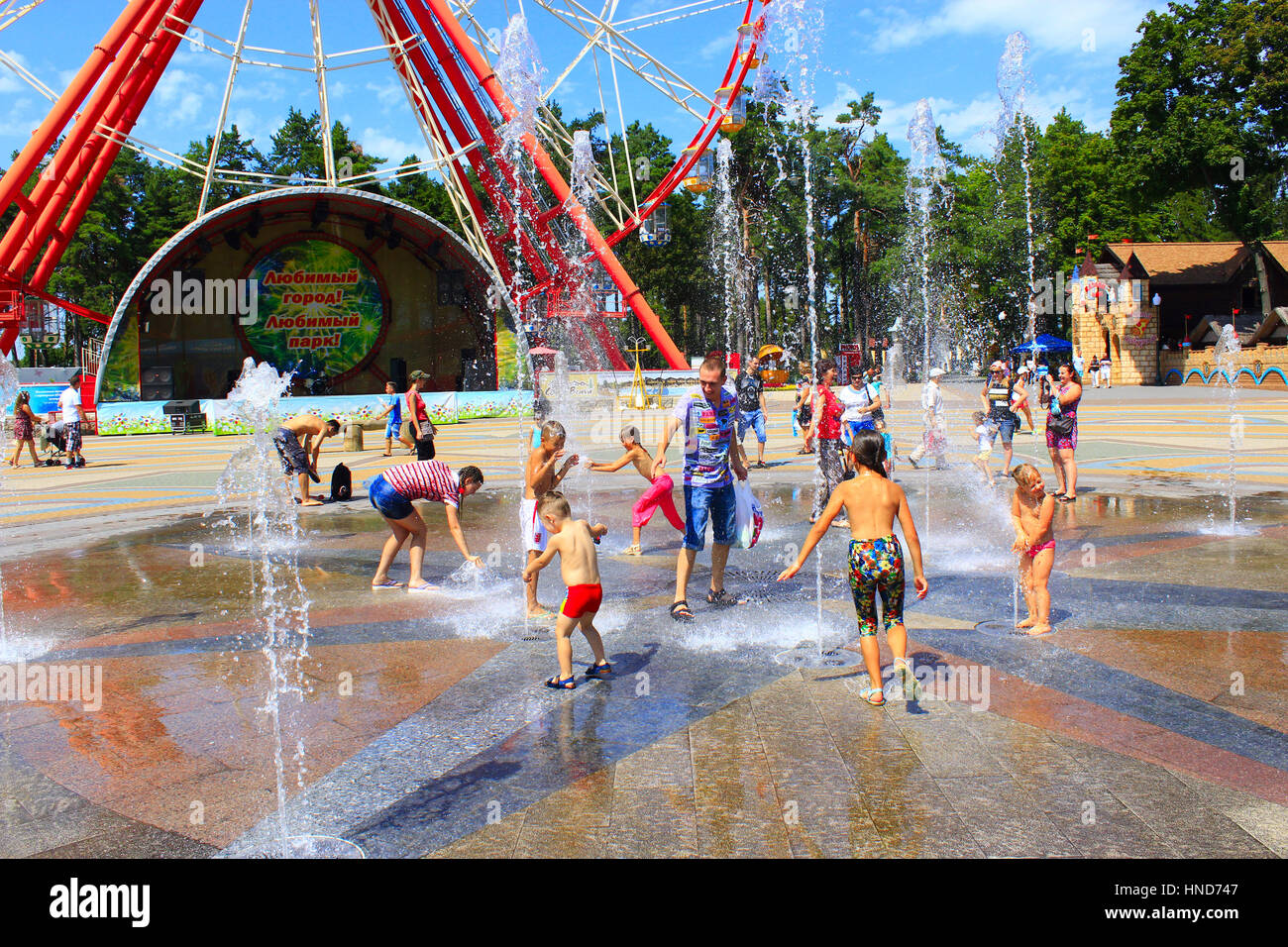 De nombreux enfants jouant sur l'aire de jeux avec leurs parents avec des fontaines dans le Parc Gorky à Kharkiv Banque D'Images