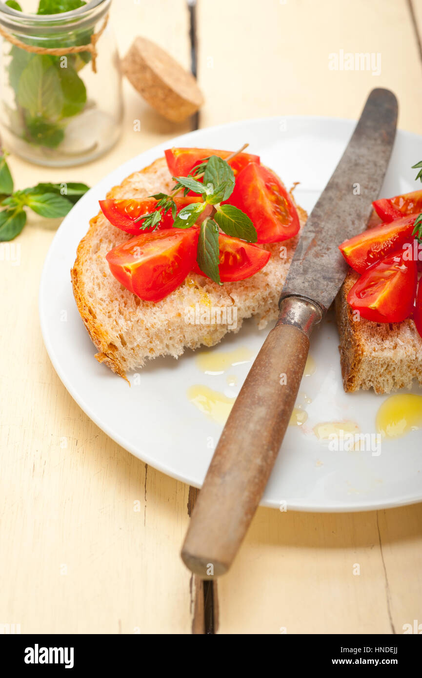 Bruschetta aux tomates italiennes avec le thym et les feuilles de menthe Banque D'Images