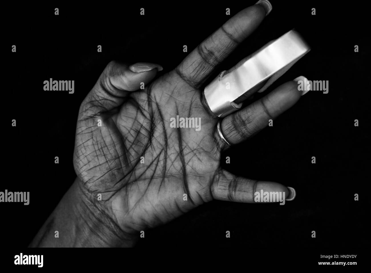 Joliment entretenus main de femme afro-américaine avec cast pour l'arthrite ou doigt fracturé Banque D'Images