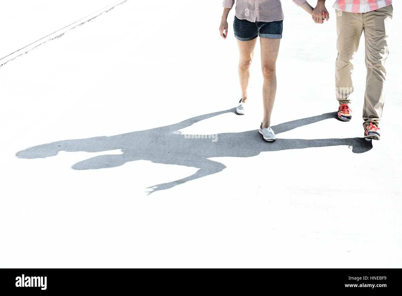 La section basse du couple walking on street Banque D'Images