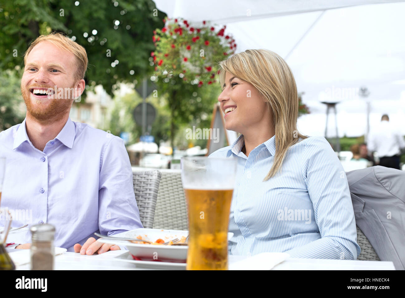 Happy businessman and businesswoman sitting at outdoor restaurant Banque D'Images