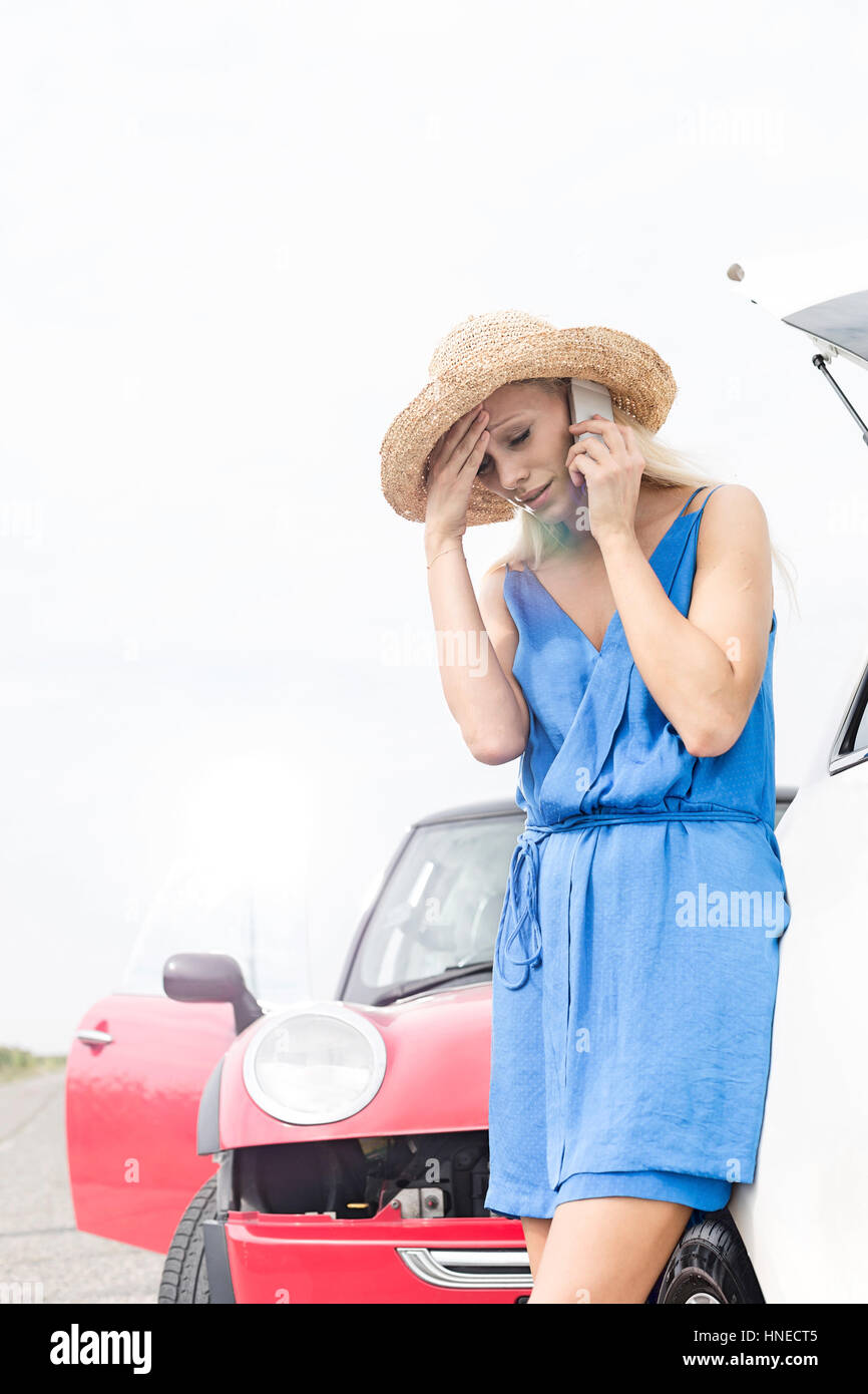 Tendu young woman using cell phone par ventilées voitures Banque D'Images