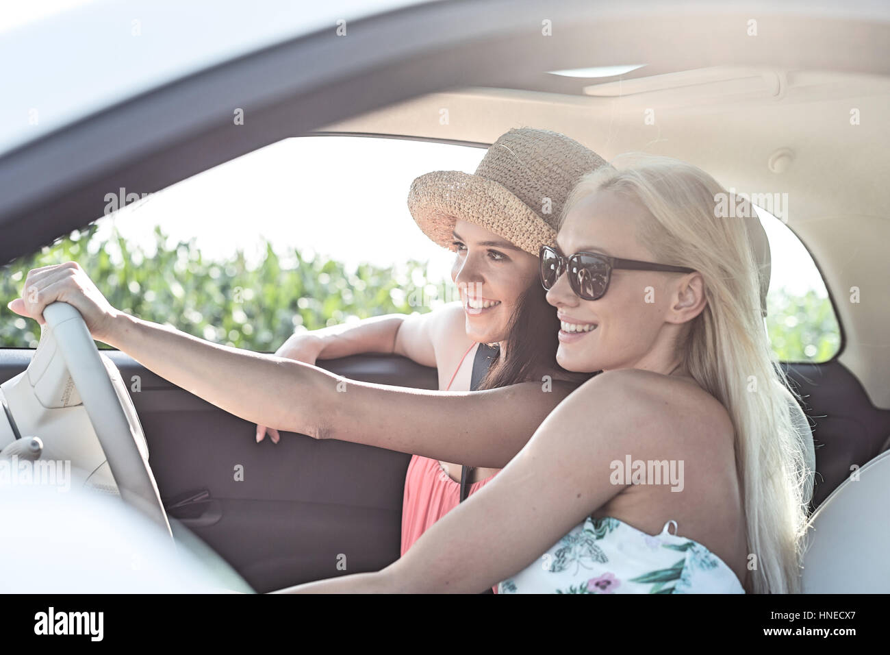 Happy female friends enjoying en voiture sur sunny day Banque D'Images