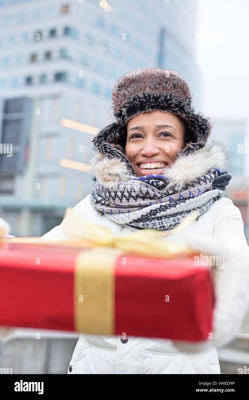 Happy woman holding gift durant l'hiver en ville Banque D'Images