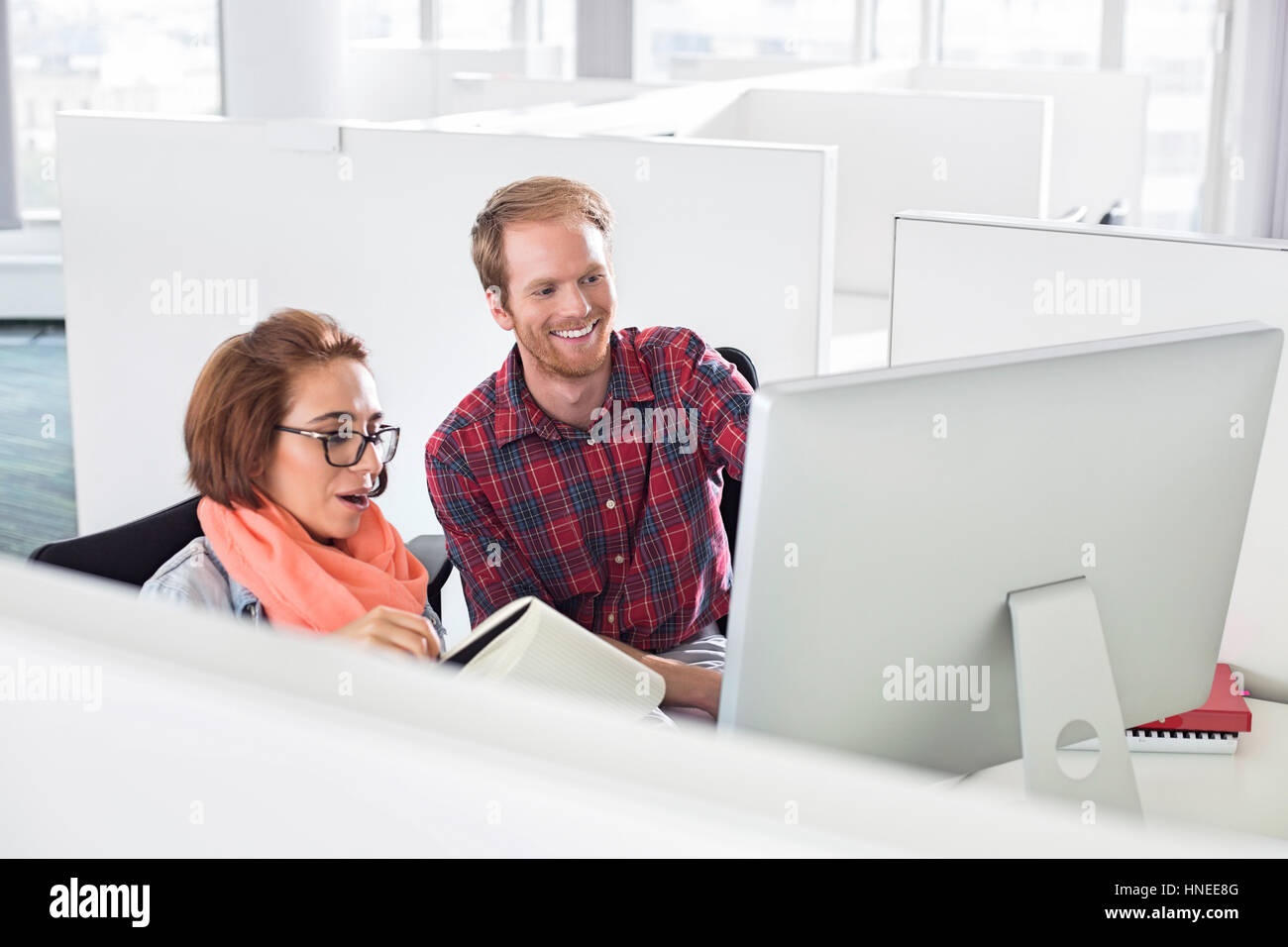 Businessman and businesswoman using computer in creative office Banque D'Images