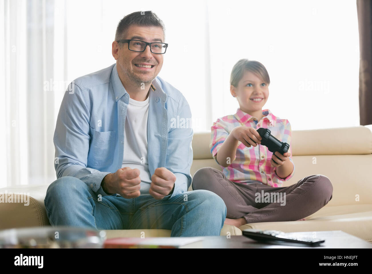 Heureux père et fille profitant de jeu vidéo dans la salle de séjour Banque D'Images