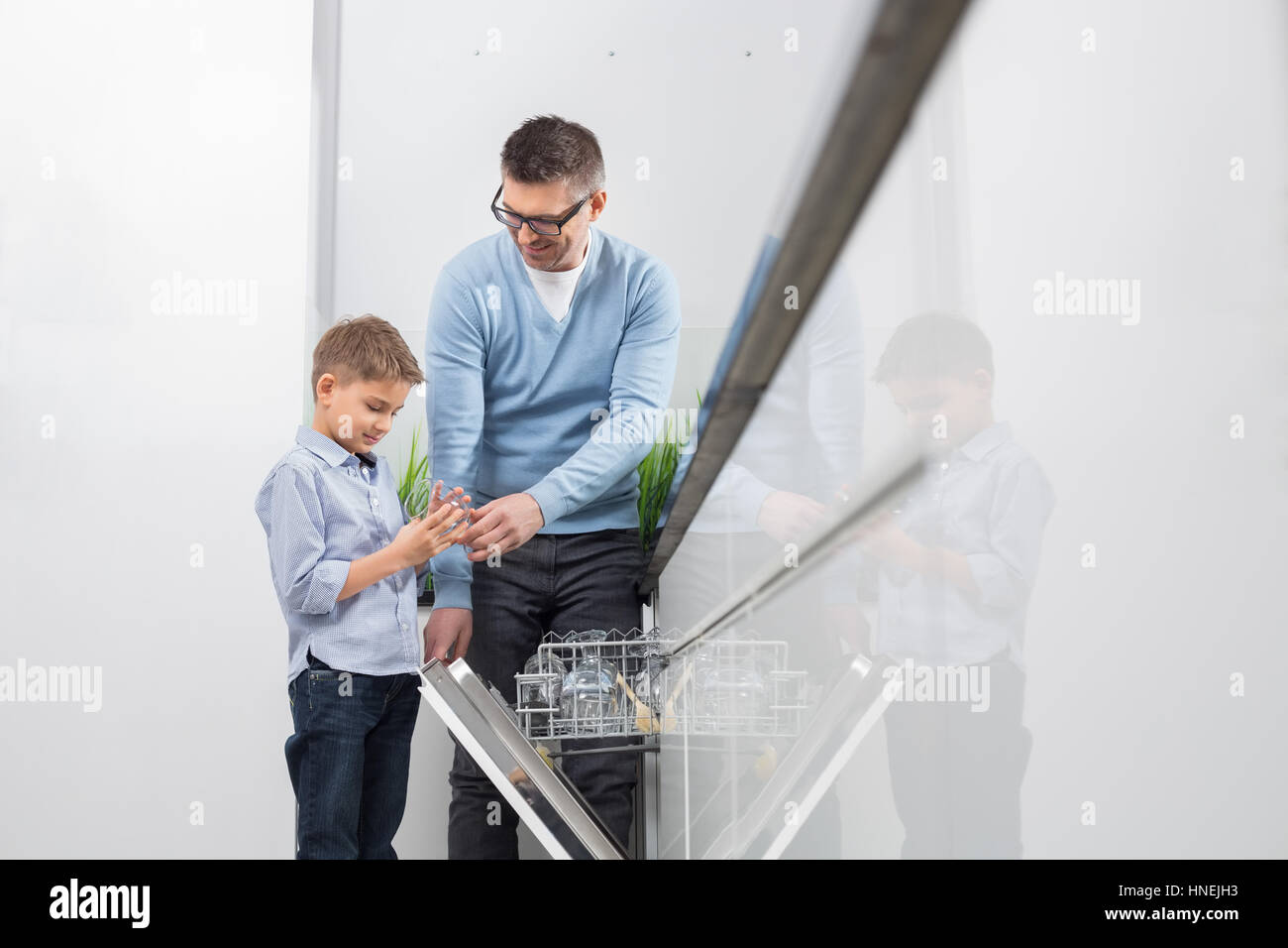 Père et fils en verre cuisine au lave-vaisselle Banque D'Images