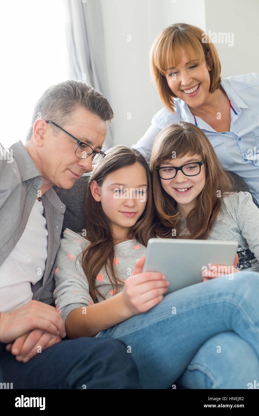 Family using digital tablet together in living room Banque D'Images