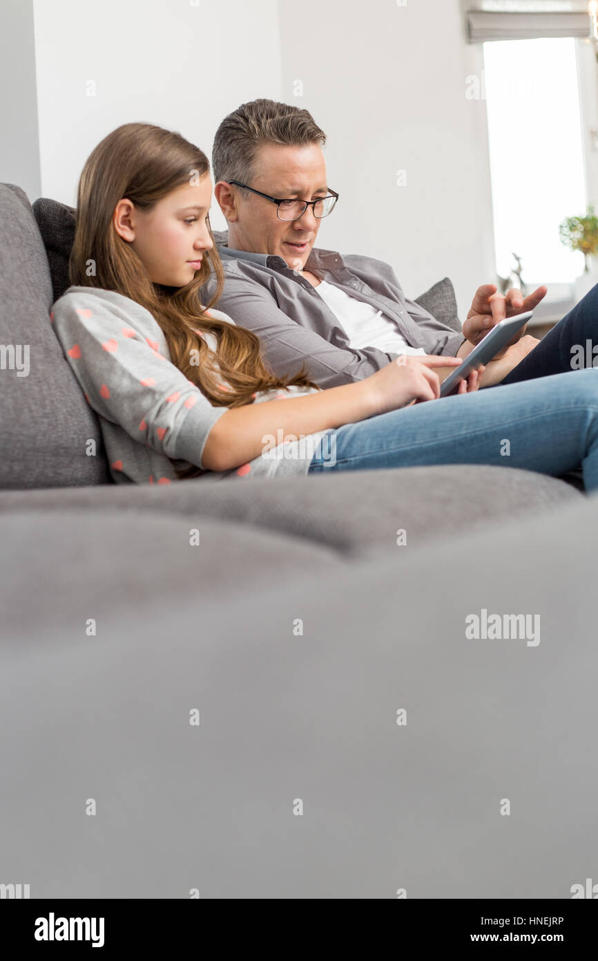 Père et fille à l'aide de tablette numérique ensemble à la maison Banque D'Images
