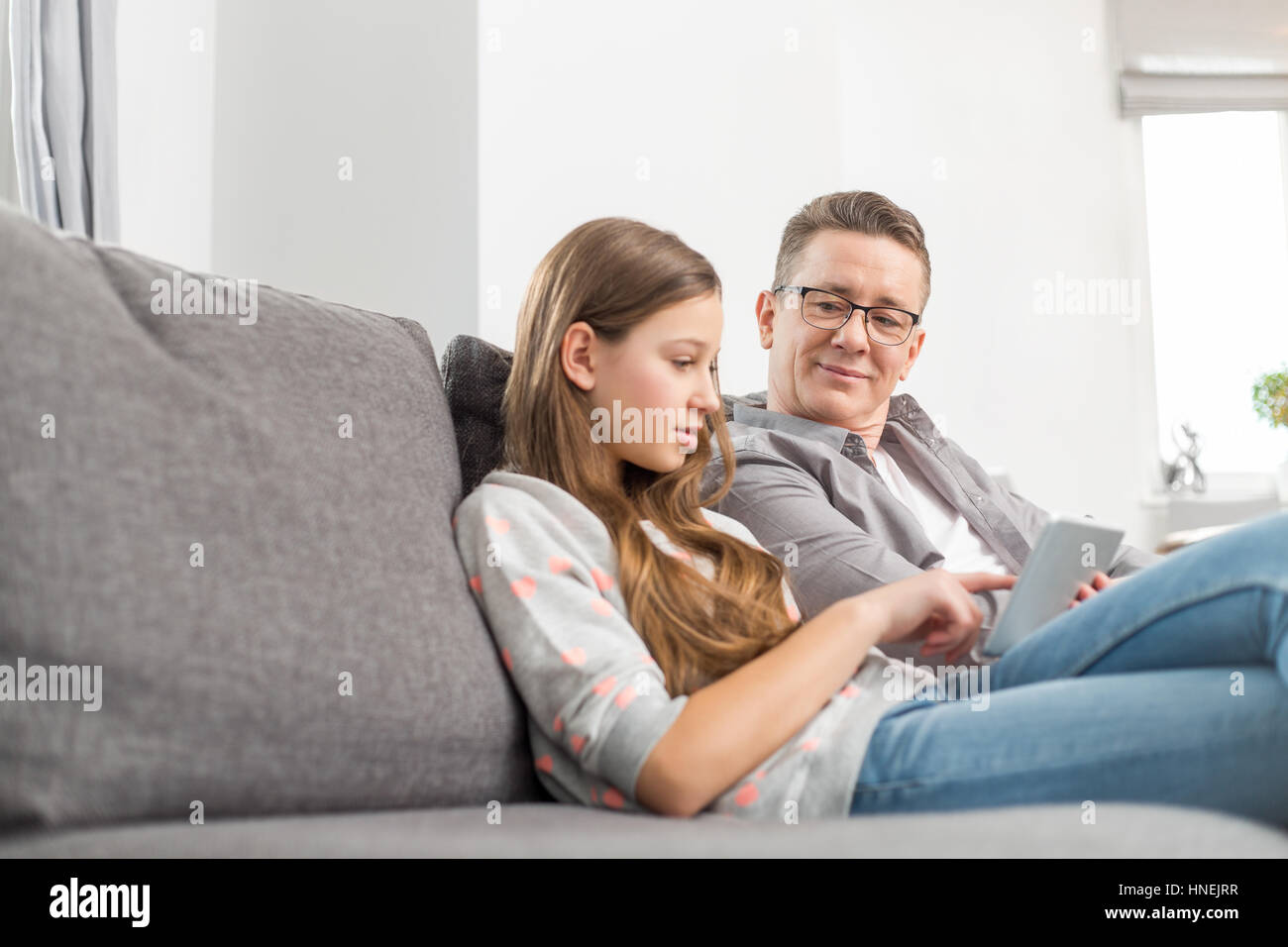 Père et fille sitting on sofa at home Banque D'Images