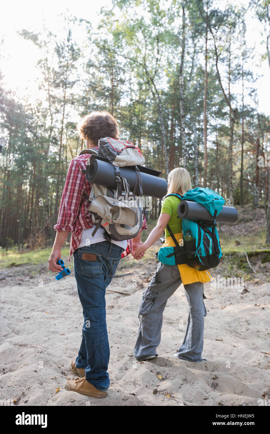 Vue arrière du couple avec des sacs de randonnée balade en forêt Banque D'Images