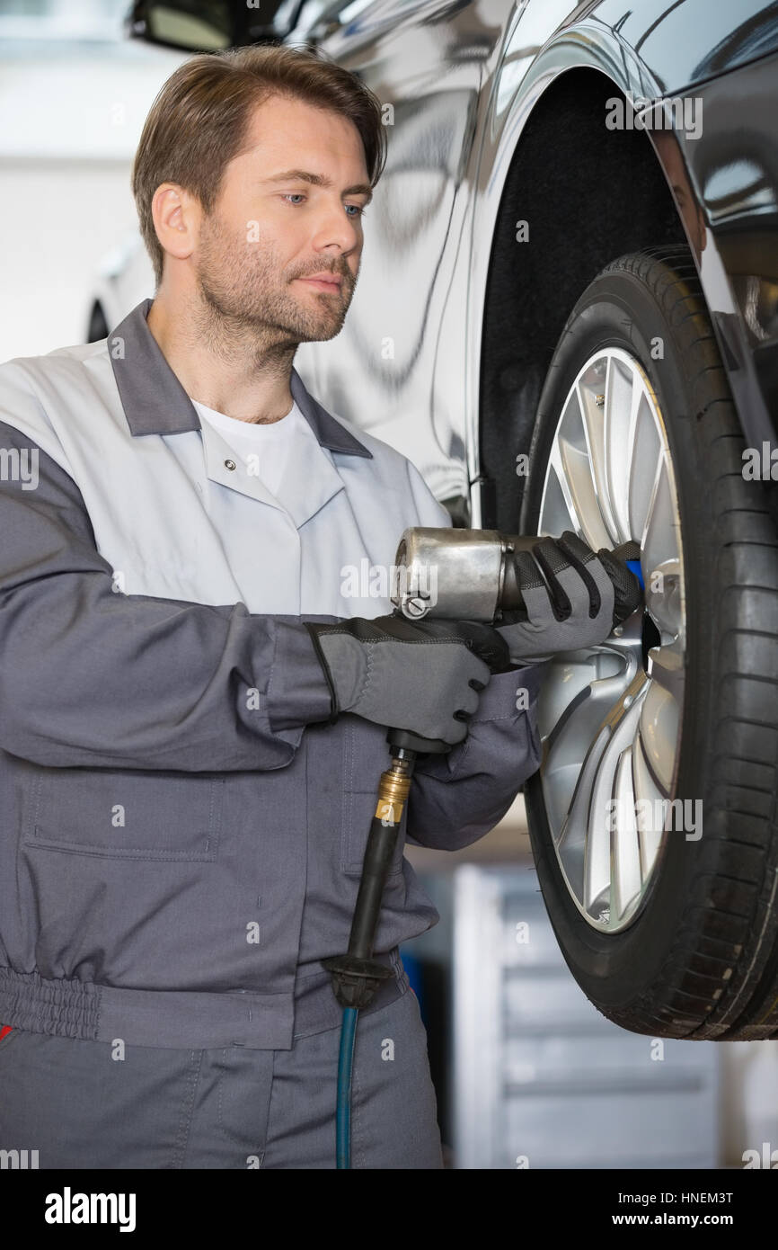 Réglage de la roue de voiture réparateur en atelier Banque D'Images