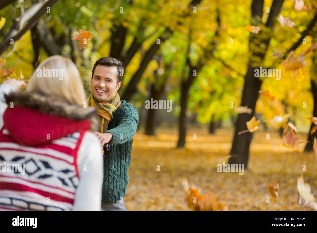 Couple heureux de jouer avec les feuilles d'automne dans le parc Banque D'Images
