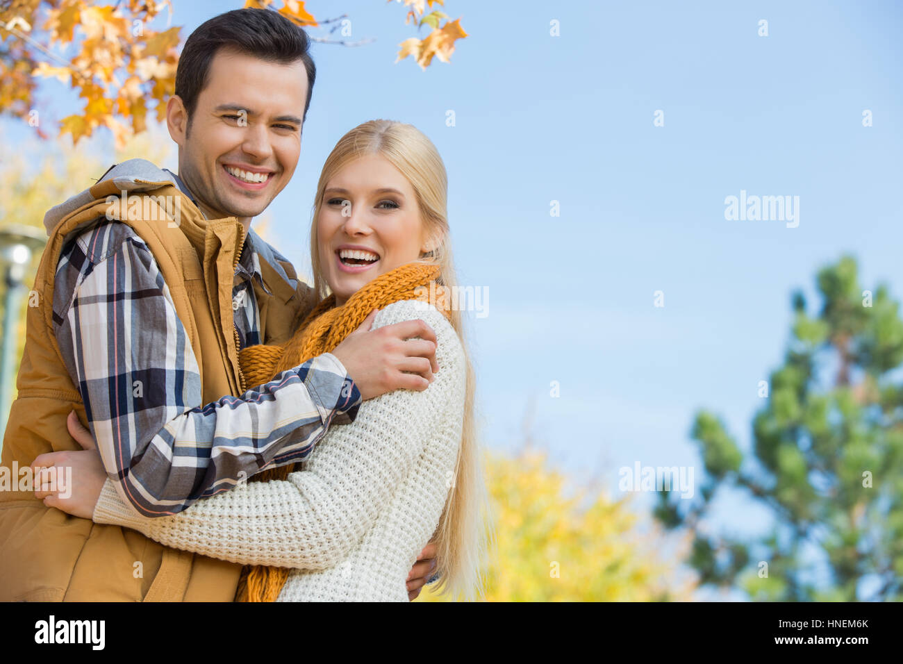 Portrait of happy couple hugging in park Banque D'Images