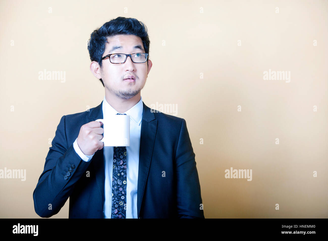 Asian businessman drinking cup of coffee Banque D'Images Asian businessman drinking cup of coffee Banque D'Images