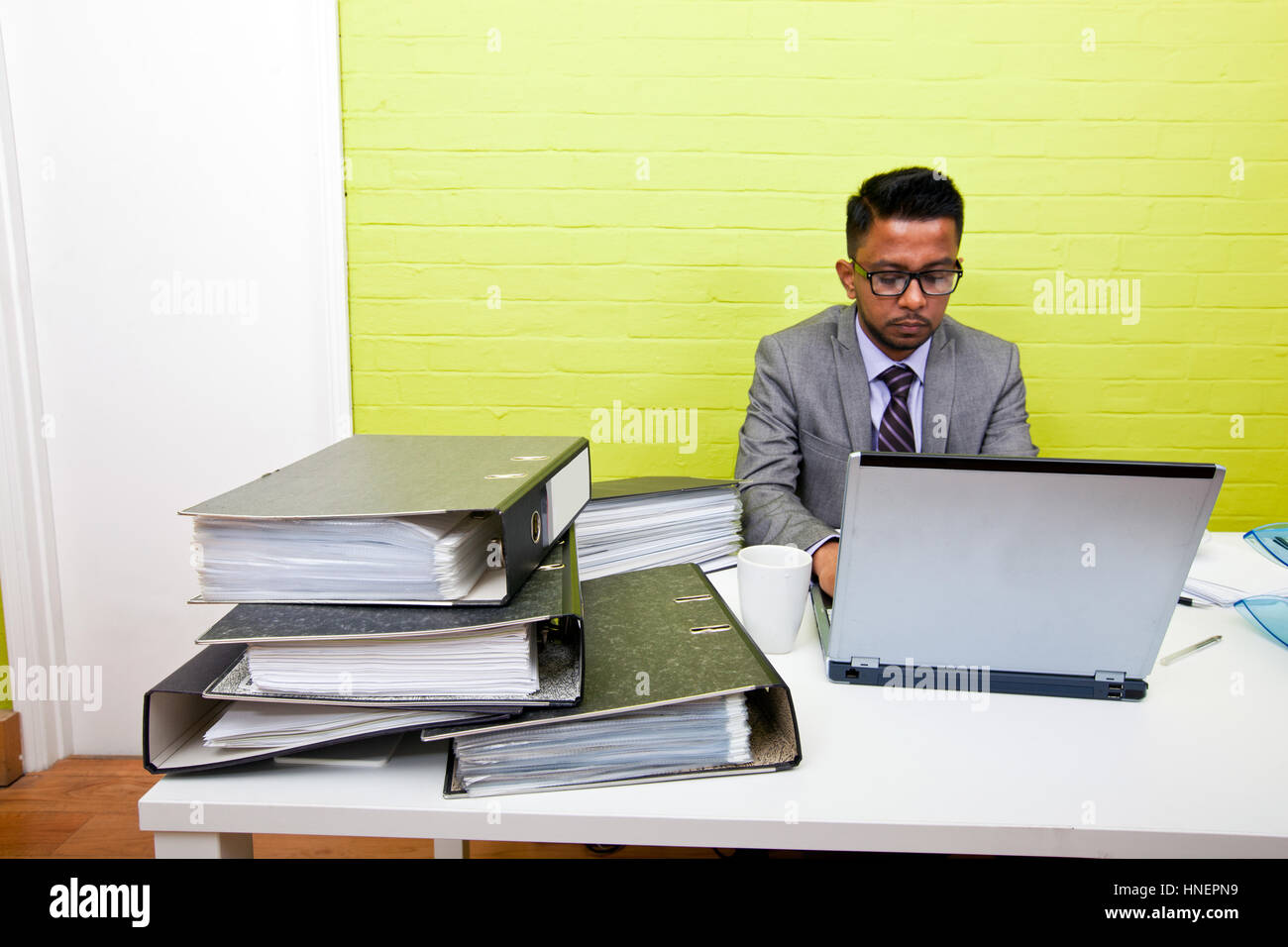 Portrait d'homme d'affaires indien travaille sur son ordinateur portable à son bureau. Banque D'Images