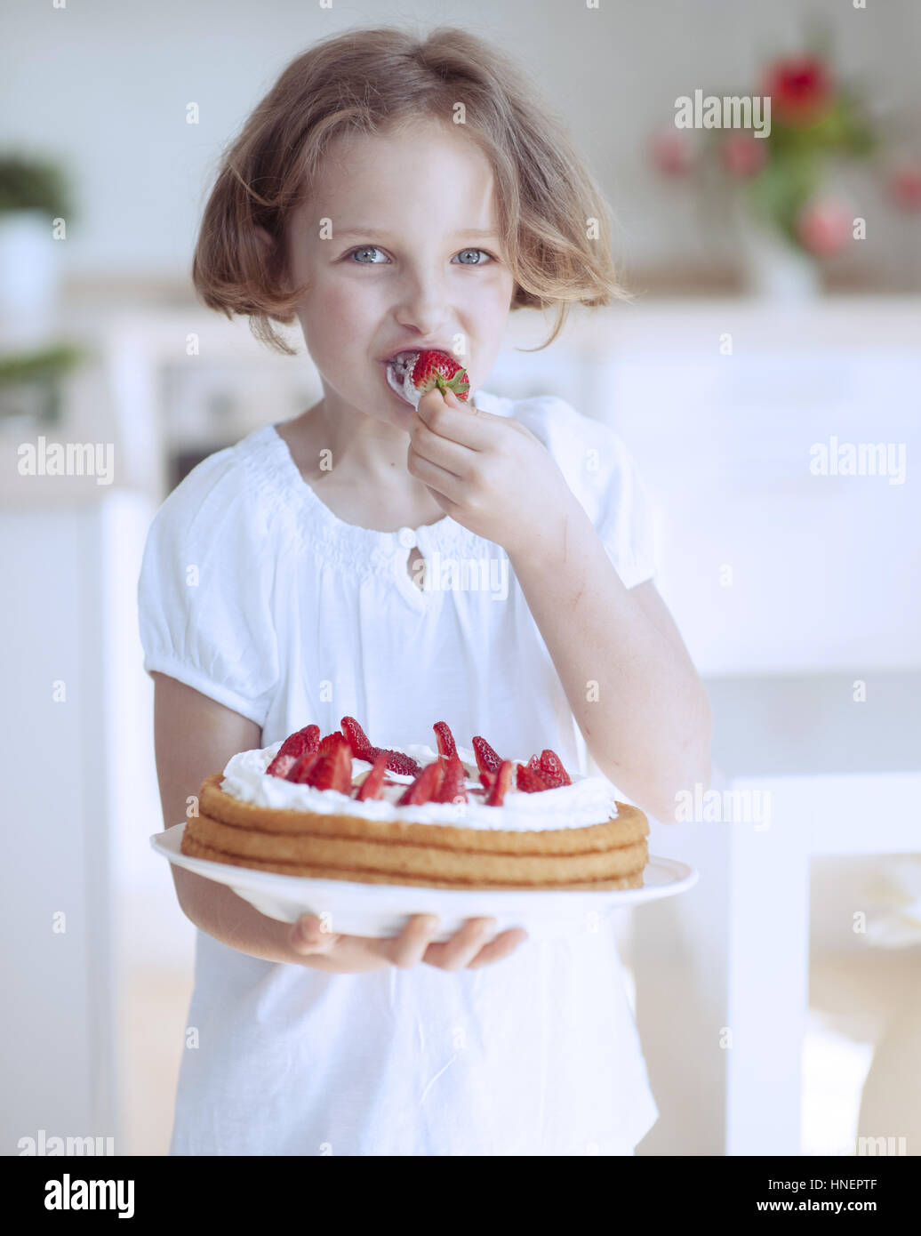 Jeune fille avec gâteau et fraises Banque D'Images