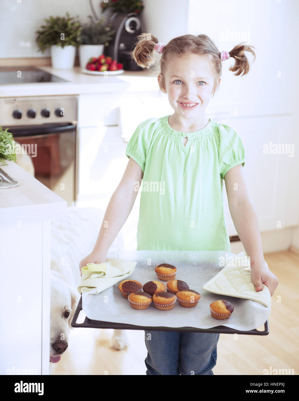 Young Girl holding de cuisson dans la cuisine Banque D'Images