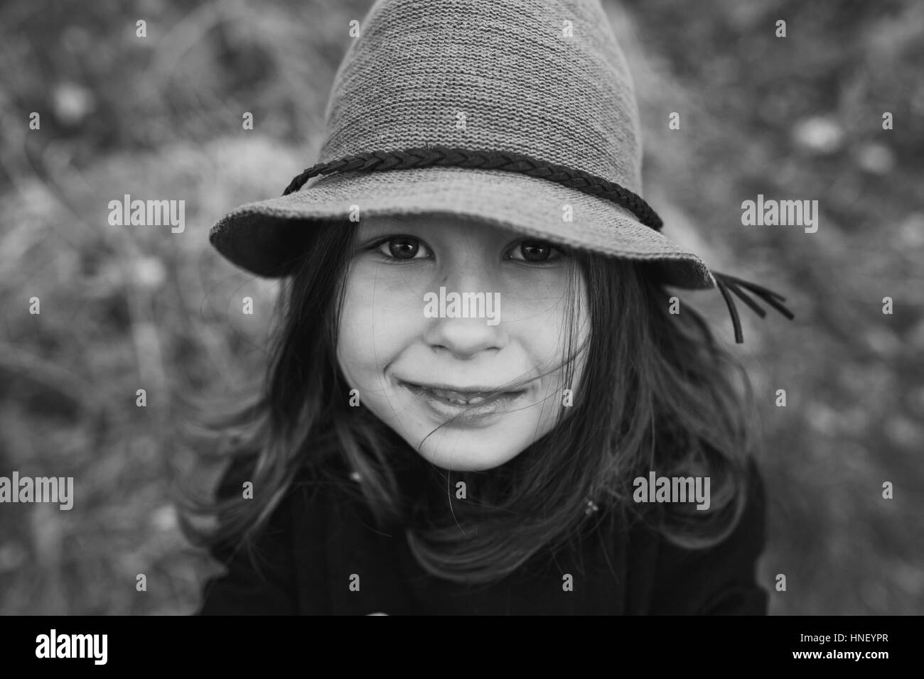 Petite fille dans un manteau noir et un chapeau Banque D'Images