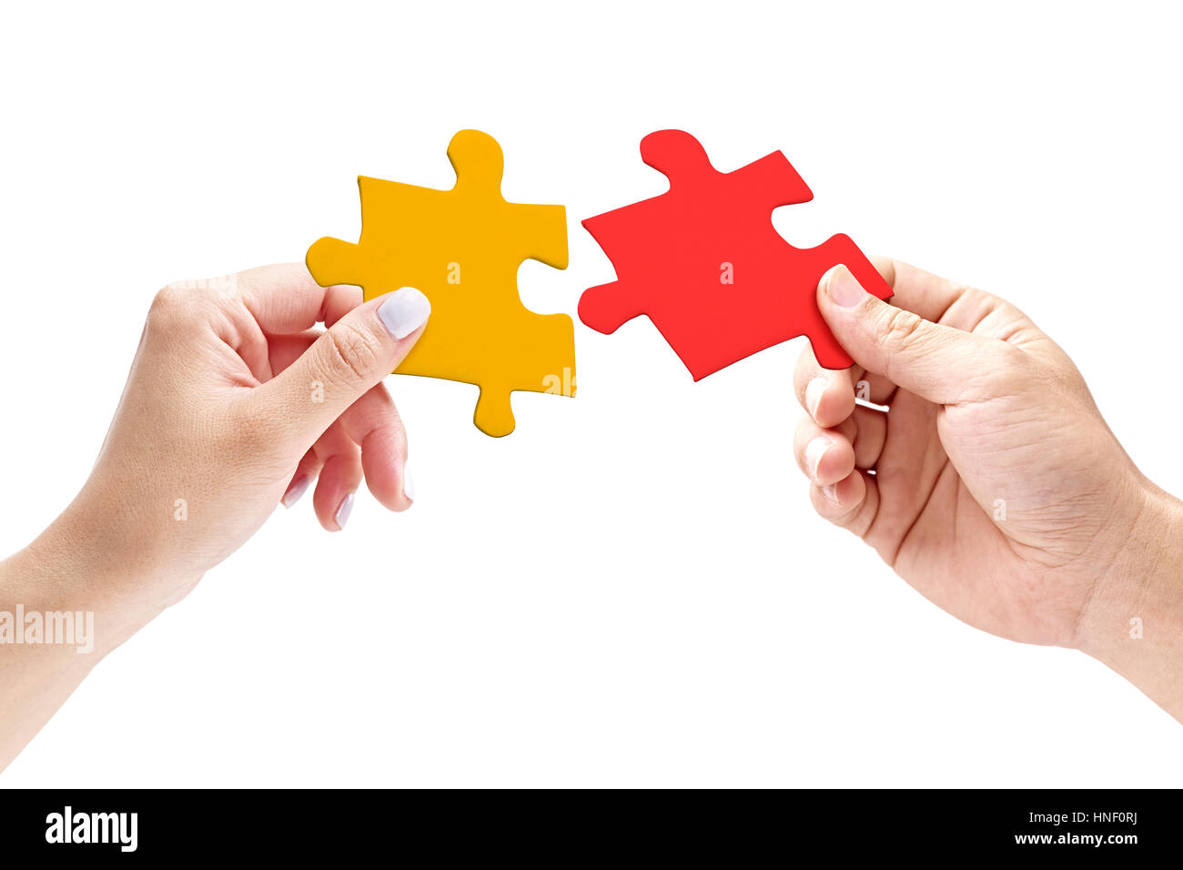 Mains d'un homme et femme de mettre ensemble deux pièces de puzzle correspondant, isolé sur fond blanc. Banque D'Images