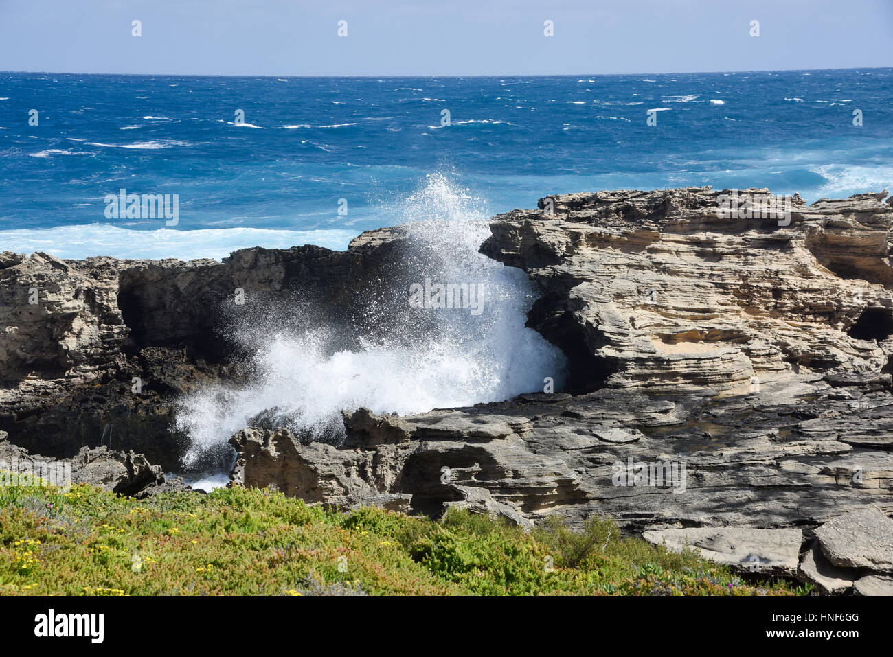 Vagues de l'Océan indien à travers le passage de pierre calcaire naturelle au Cap Vlamingh à Rottnest Island, dans l'ouest de l'Australie. Banque D'Images
