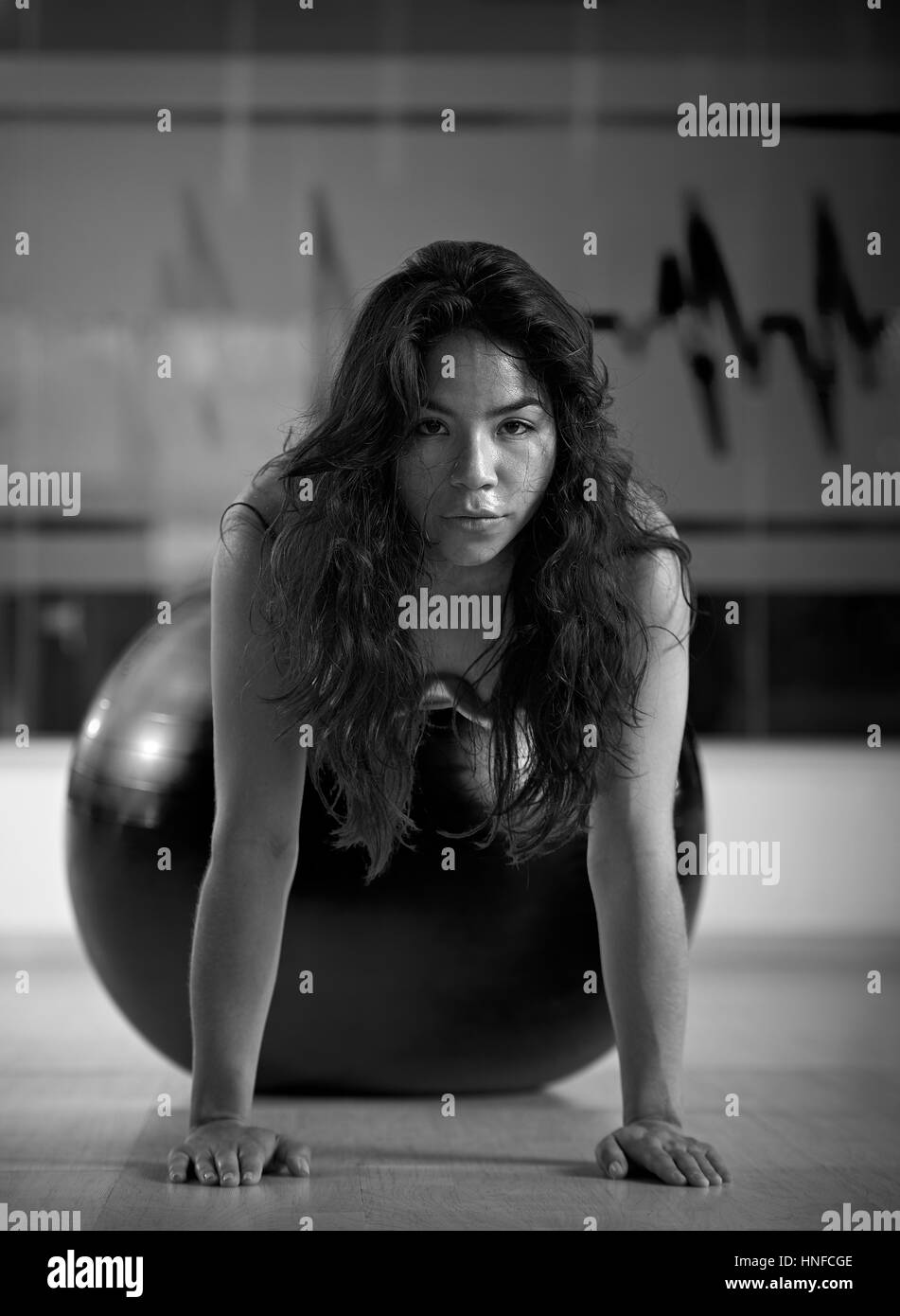 Asian girl faisant de l'exercice dans la salle de sport noir et blanc Banque D'Images