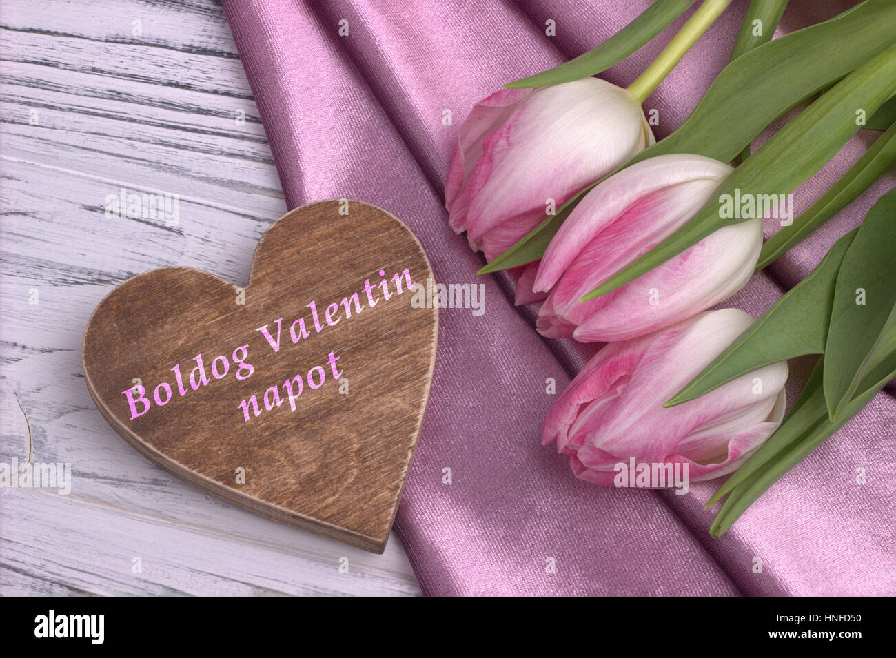 La Saint-Valentin avec la vie toujours élégante tulip rose fleurs rose tissu brillant en forme de coeur et signe sur fond en bois blanc et le lettrage heureux Valen Banque D'Images
