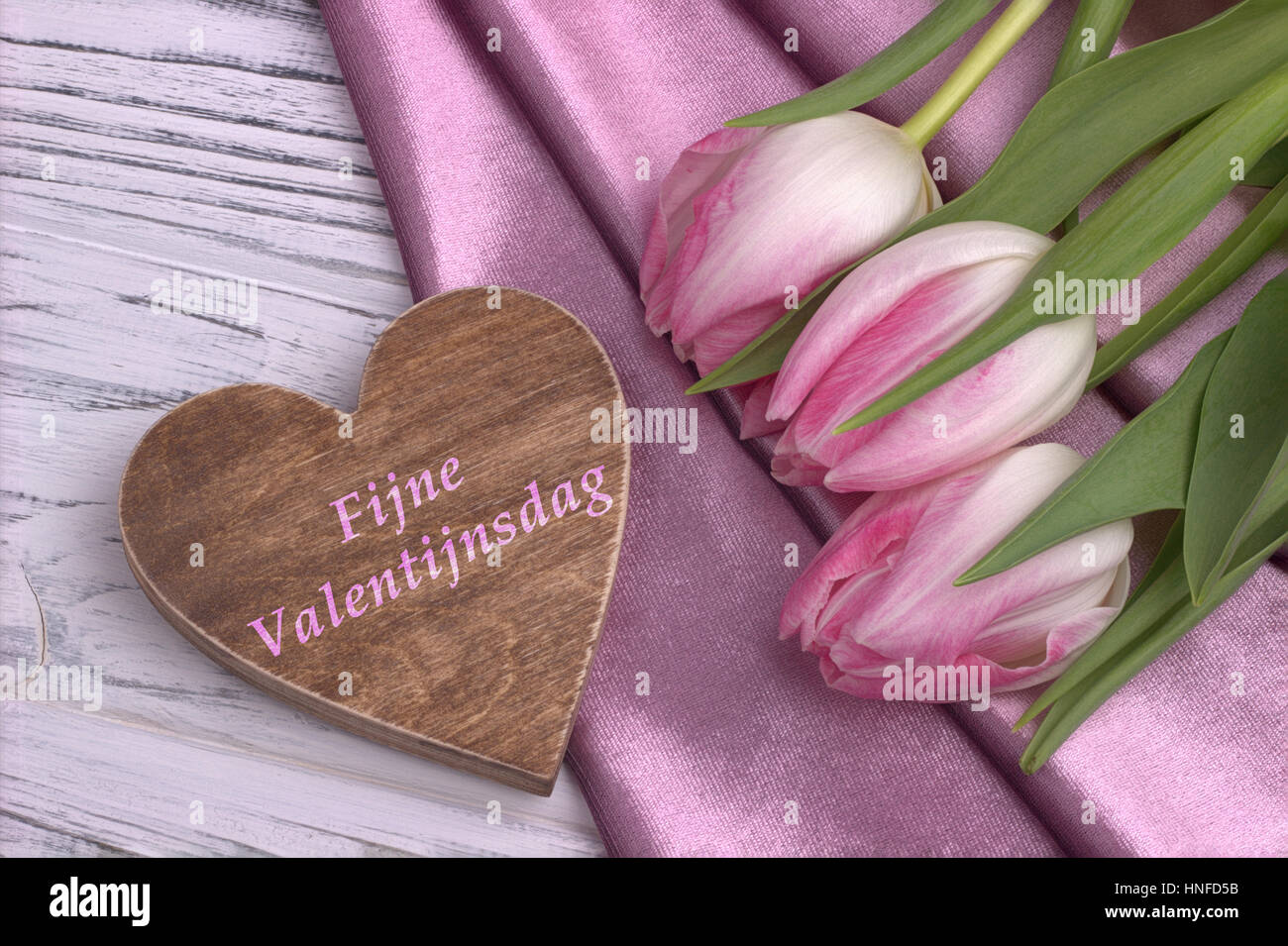 La Saint-Valentin avec la vie toujours élégante tulip rose fleurs rose tissu brillant en forme de coeur et signe sur fond en bois blanc et le lettrage heureux Valen Banque D'Images