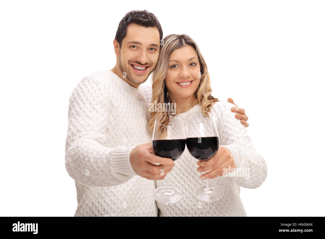Jeune couple joyeuse de faire un toast avec verres de vin isolé sur fond blanc Banque D'Images