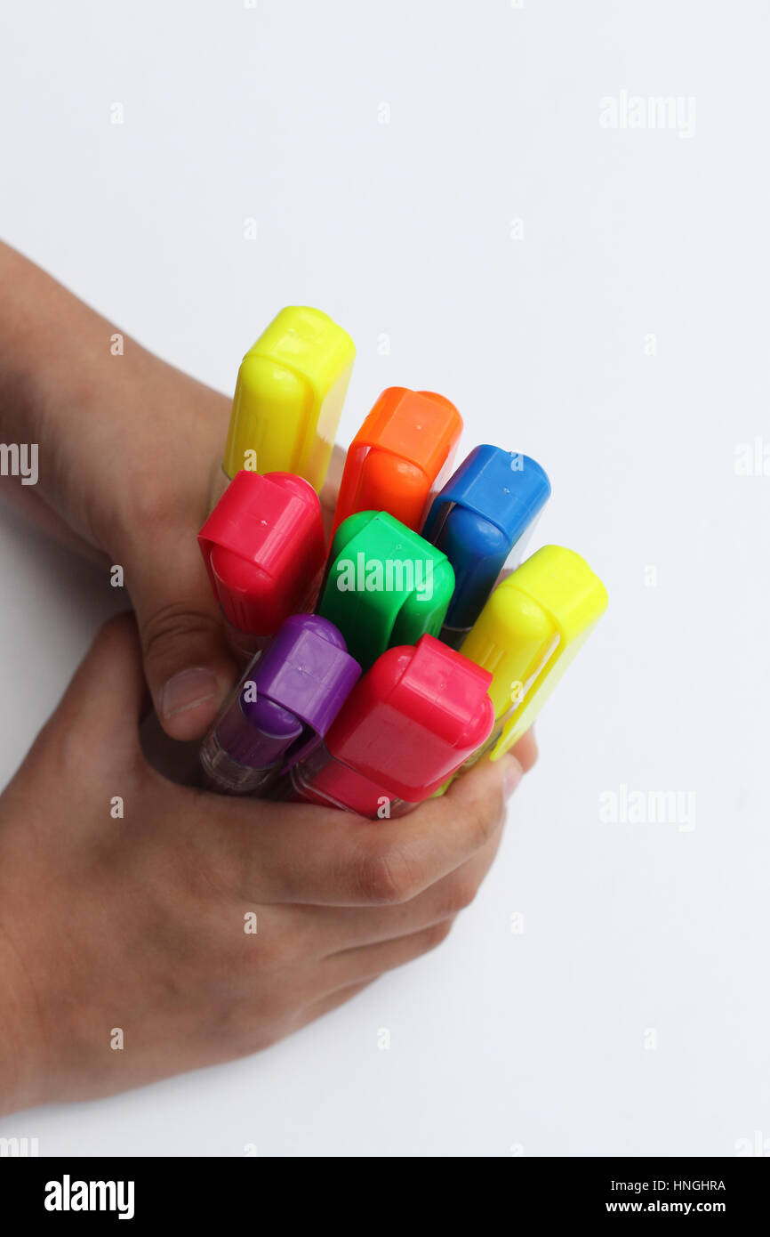 Close up of mains agrippant surligneurs colorés contre isolé sur fond blanc Banque D'Images Close up of mains agrippant surligneurs colorés contre isolé sur fond blanc Banque D'Images