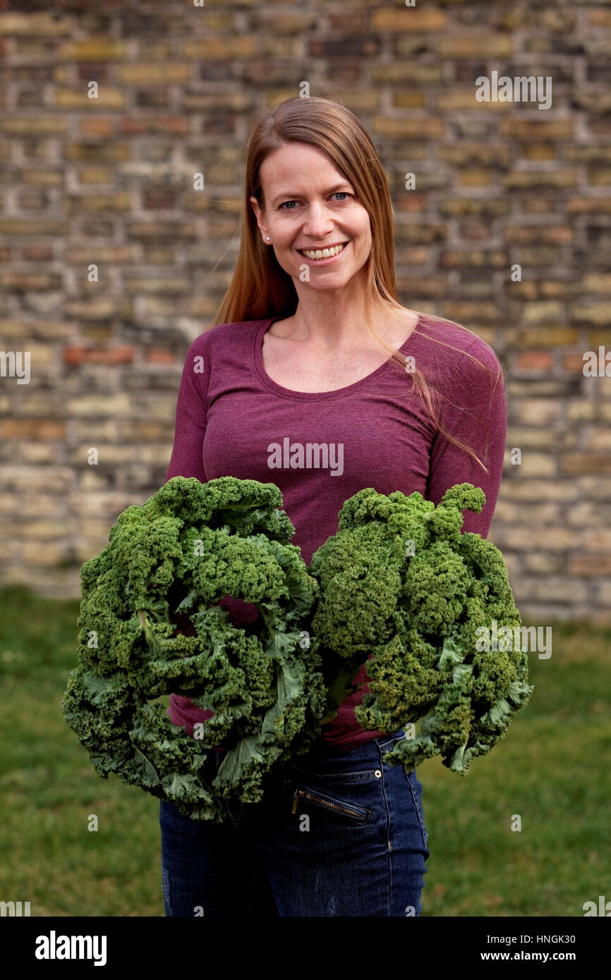 Femme avec kale in garden Banque D'Images