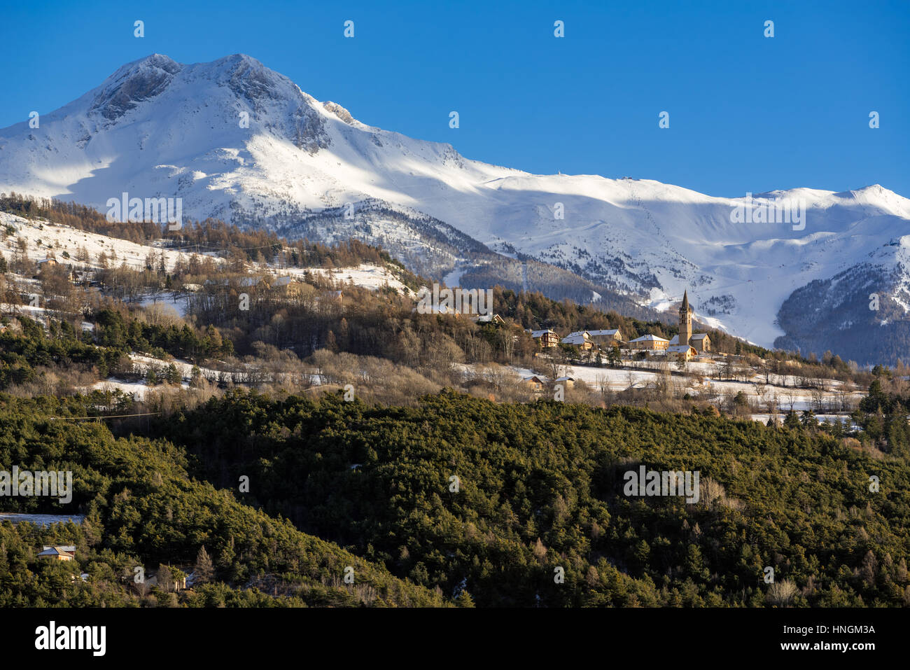 Village de Saint-Sauveur près d'Embrun avec vue d'hiver sur la station de ski des Orres. Hautes-Alpes, Alpes du Sud, France Banque D'Images