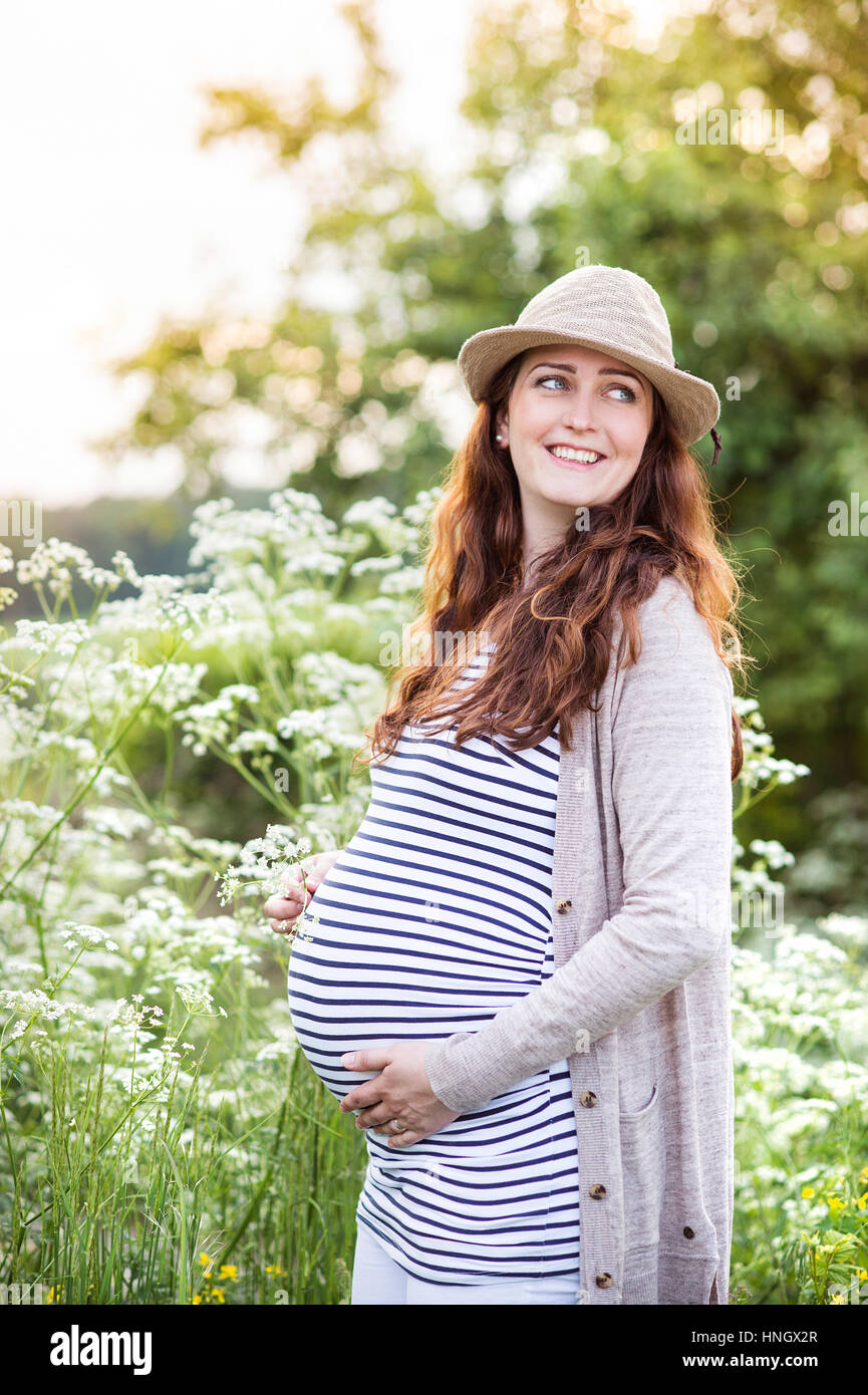 Belles femmes enceintes tenant son ventre. Nature de l'été. Banque D'Images