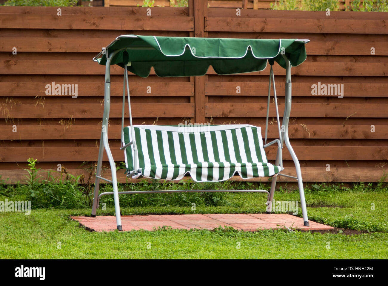 Green metal swing sur la pelouse de trèfle Banque D'Images