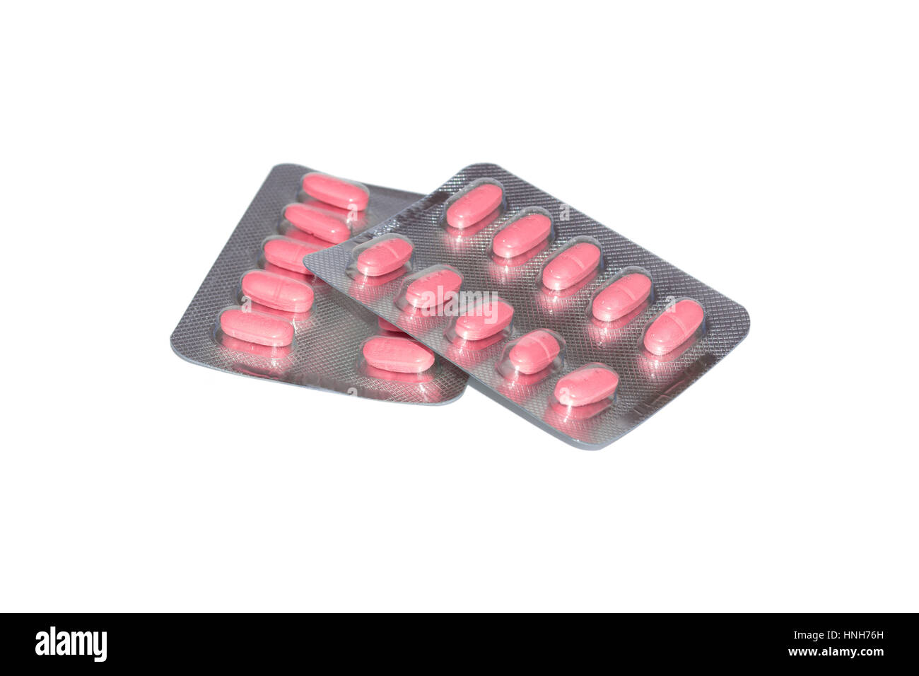 Pilules roses conditionnés dans des blisters isolé sur fond blanc Banque D'Images