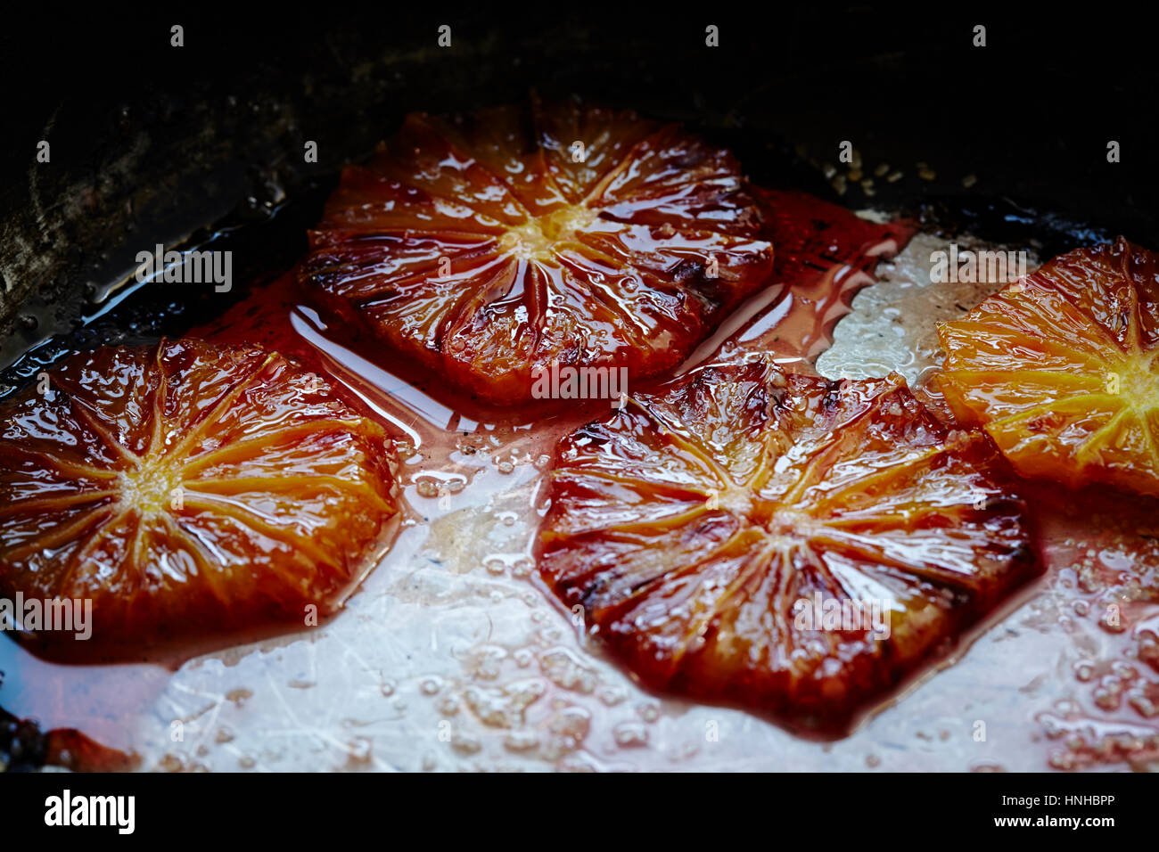 Tranches d'orange sanguine par cuisson dans une casserole. Banque D'Images