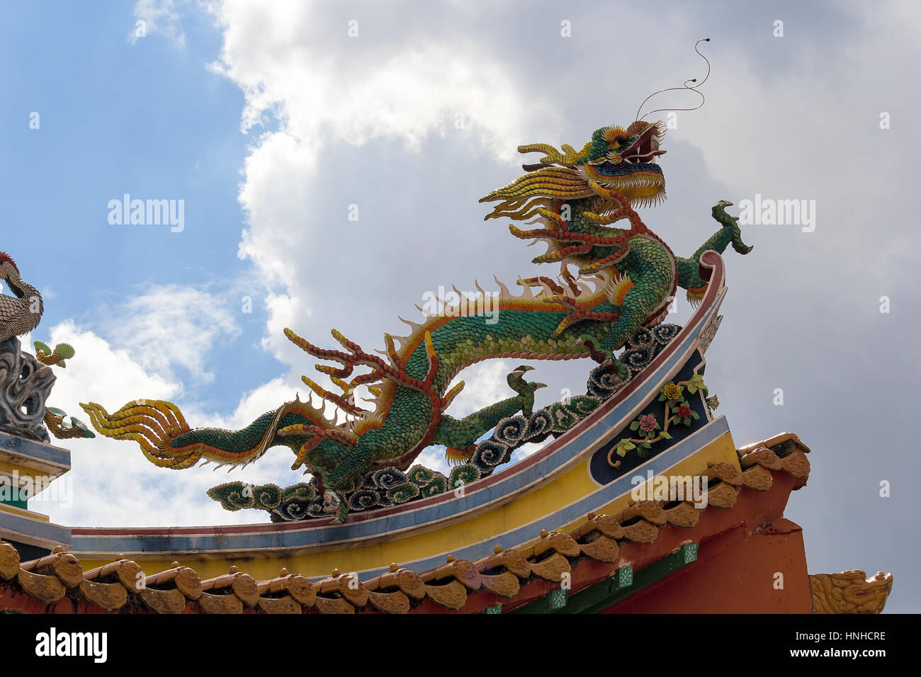 Sculpture mythique Dragon chinois sur le toit du temple contre ciel nuageux Banque D'Images