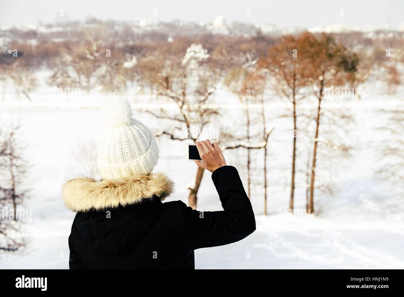 Jolie Fille de prendre des photos avec un téléphone mobile en hiver Banque D'Images
