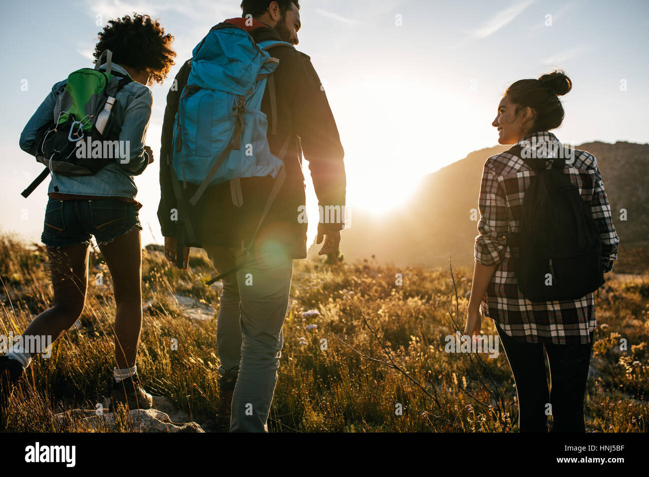 Vue arrière photo de jeunes amis dans la campagne pendant des vacances randonnée. Groupe de randonneurs marchant dans la nature. Banque D'Images