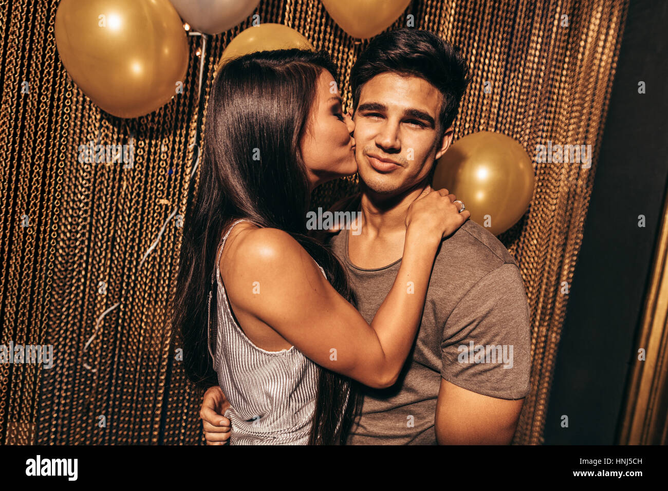 Coup de jeune couple aimant dans la boîte de nuit. Young woman kissing her boyfriends dans la partie au pub. Banque D'Images