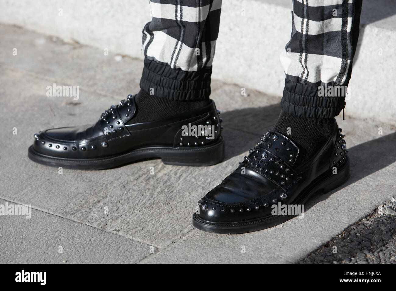 L'homme en cuir noir avec des chaussures à clous et un pantalon à carreaux  avant de Salvatore Ferragamo fashion show, Milan Fashion Week street Photo  Stock - Alamy