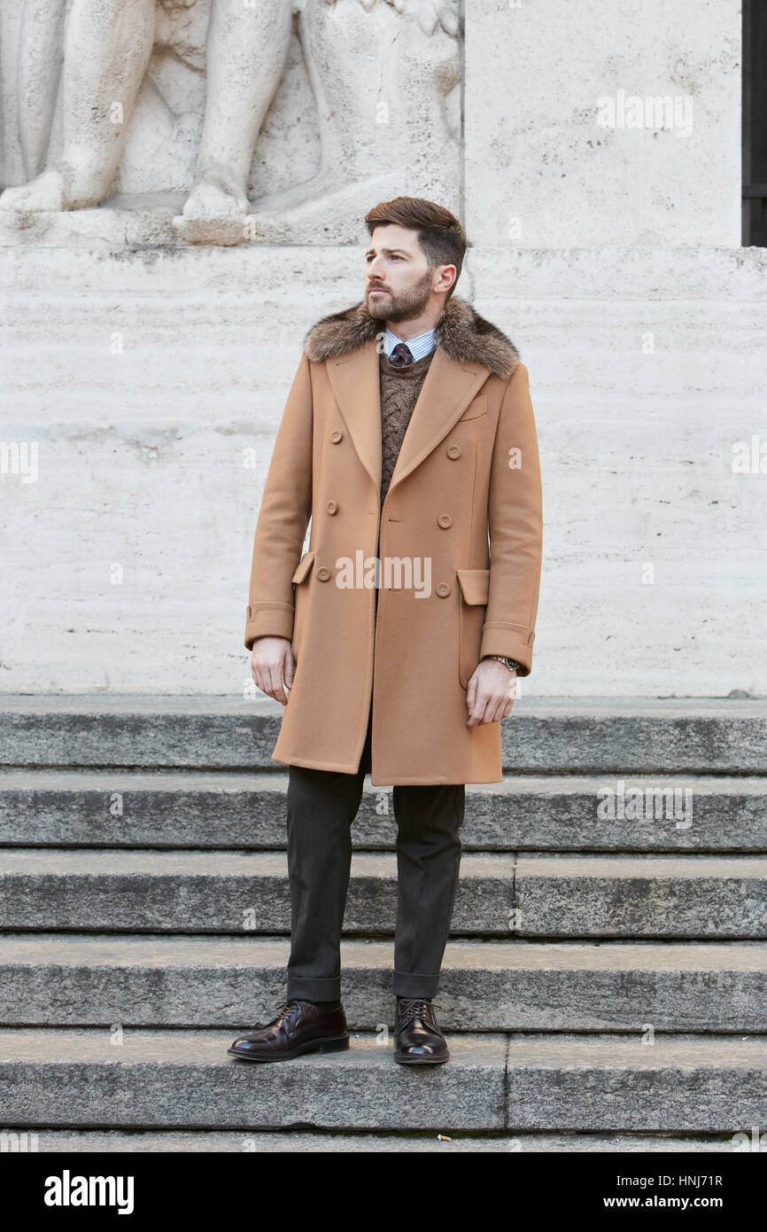 Homme avec manteau beige et col fourré avant de Salvatore Ferragamo fashion show, Milan Fashion Week street style le 15 janvier 2017 à Milan. Banque D'Images