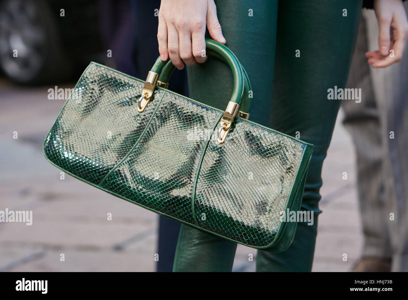 Femme Sac en cuir de reptile en cuir et pantalon avant de Salvatore Ferragamo fashion show, Milan Fashion Week street style. Banque D'Images