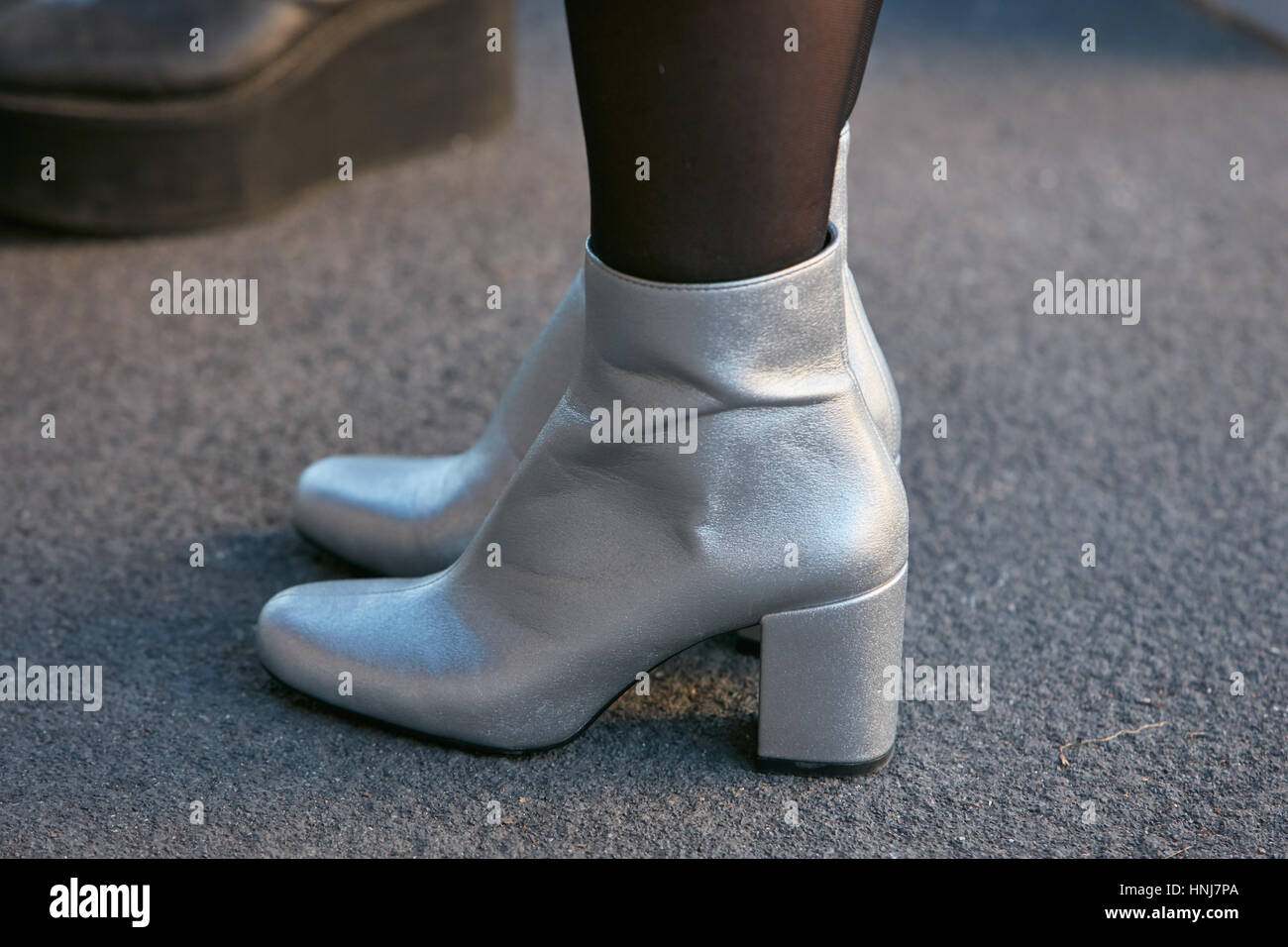 Femme avec talon haut bottes avant d'argent MSGM fashion show, Milan Fashion Week street style le 16 janvier 2017 à Milan. Banque D'Images